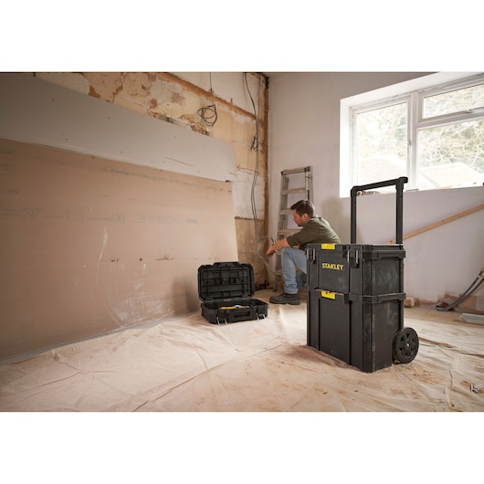 Photo of STANLEY STST60500 rolling tool box and open case on jobsite, black with yellow accents.