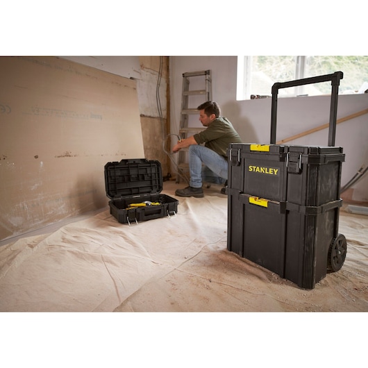 Photo of STANLEY STST60500 black rolling tool chest and open toolbox in a workshop setting.