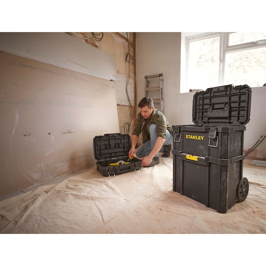 STANLEY STST60500 rolling toolbox set with open compartments, shown in a workshop with tools inside.