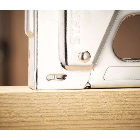 STANLEY TR45 silver staple gun close-up on light wood surface, side angle.