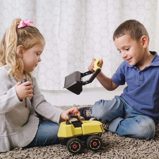 STANLEY TT002-SY toy excavator photography, yellow and black, children playing on carpet, front angle.